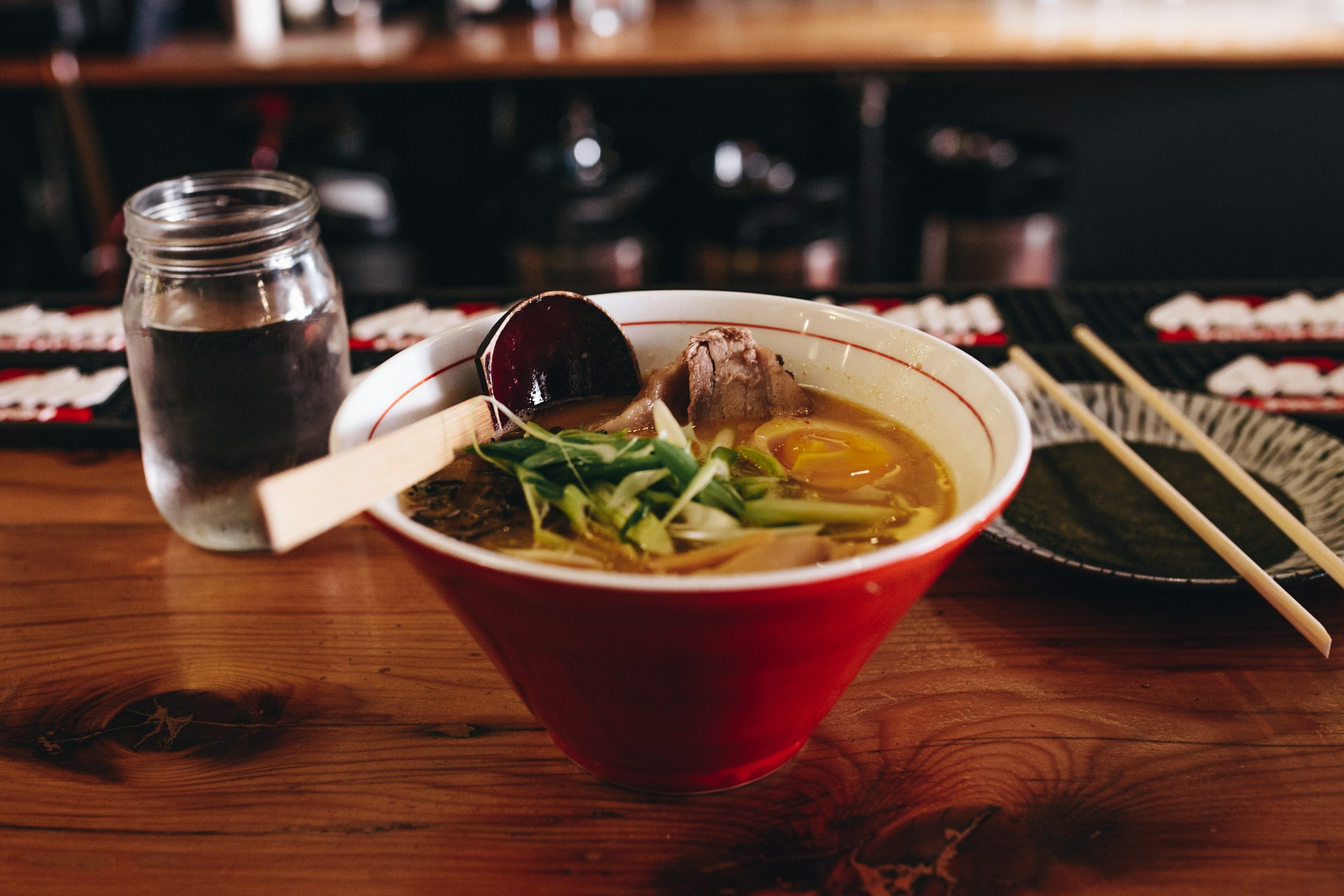 Ramen mit frischen Toppings in einer roten Keramikschale